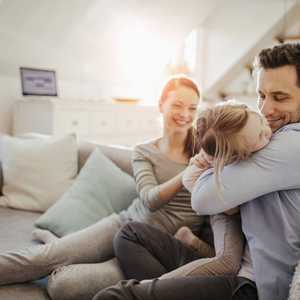 Parents Playing with Child on Sofa on A Sunny Day 1