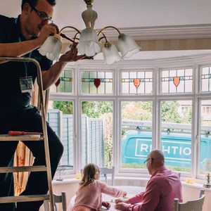 Engineer Checking Light Fittings in Living Room