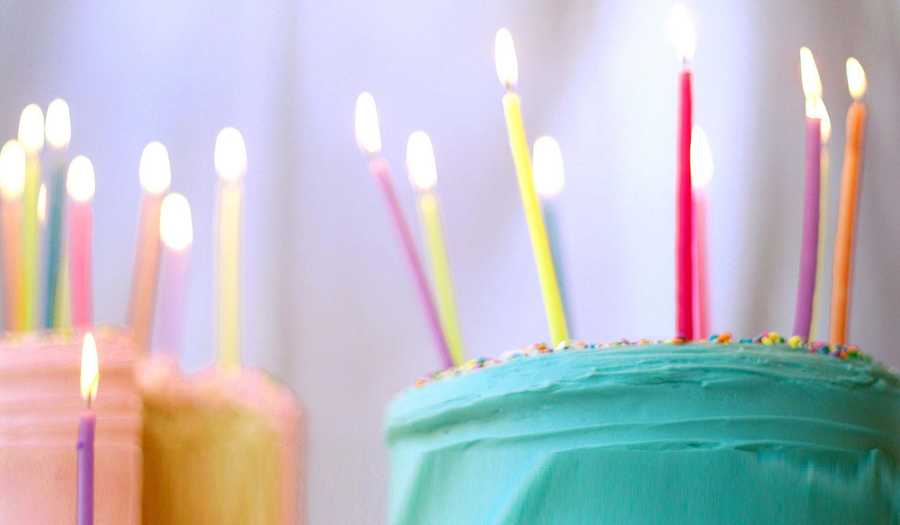 Green and Pink Birthday Cakes with Lit Candles