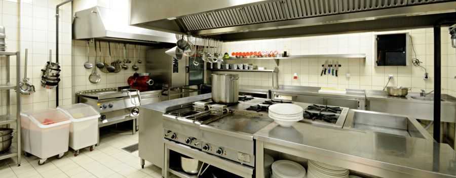 A Very Clean Commercial Kitchen With Plates Oven Pots Pans Stove Knives and Sink