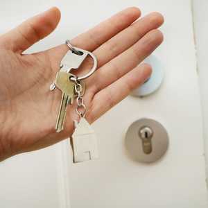 Person Holding Keys to Door