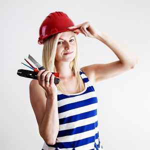 Woman Weating Red Helmet and Holding Tools