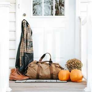 White Doorway with Coat Boots Holdall Pumpkins and Flowers on Porch