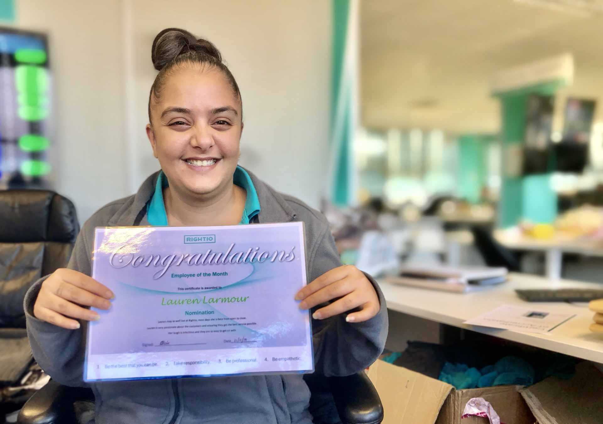 Lauren Smiling with Her Employee of The Month Certificate
